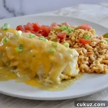 Green Chili Chicken Burritos on a white plate with mexican rice.