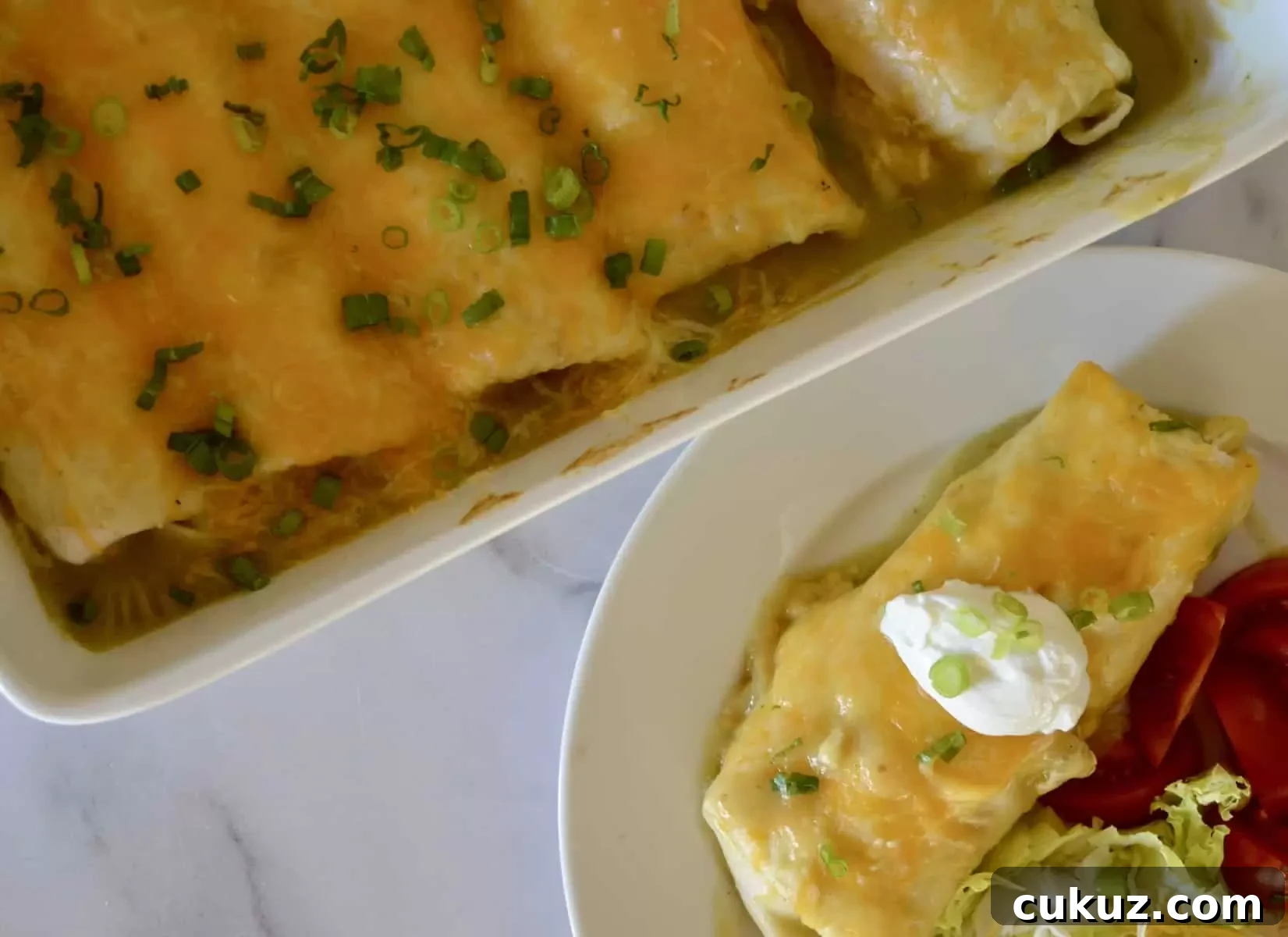 cassorole dish with smothered burritos and a white plate with burrito and tomatoes on it