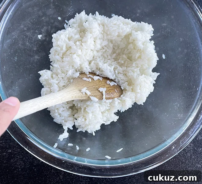 sticky rice in a glass bowl with a wooden spatula
