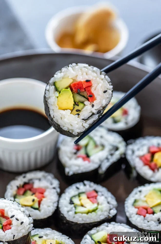 pair of chopstick holding a vegan sushi roll