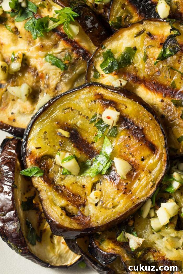 Perfectly Grilled Eggplant Recipe for Smoky Summer Flavor 5 closeup of grilled eggplant served in chopped garlic marinade
