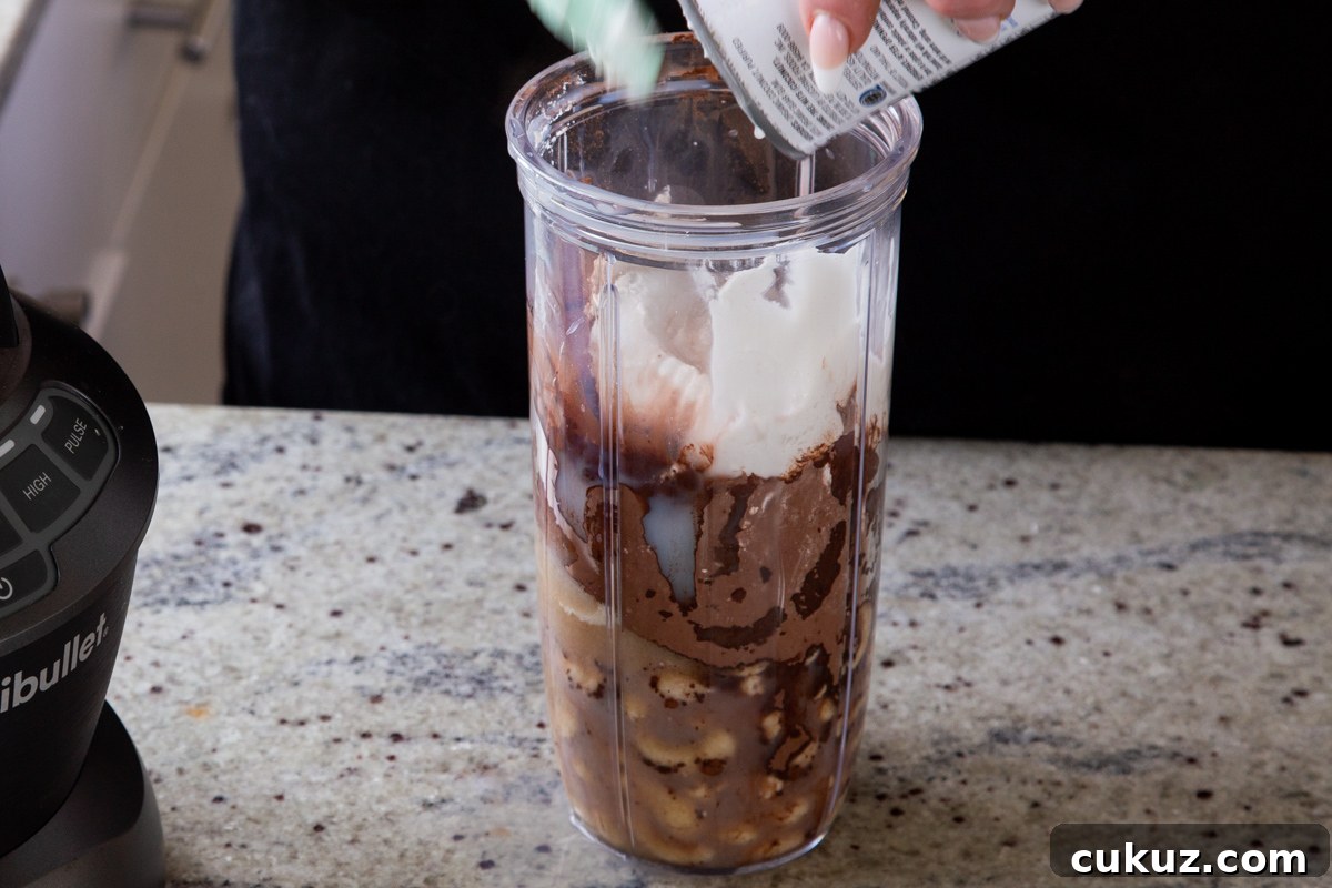 adding coconut cream to the blender with the other chocolate pudding ingredients
