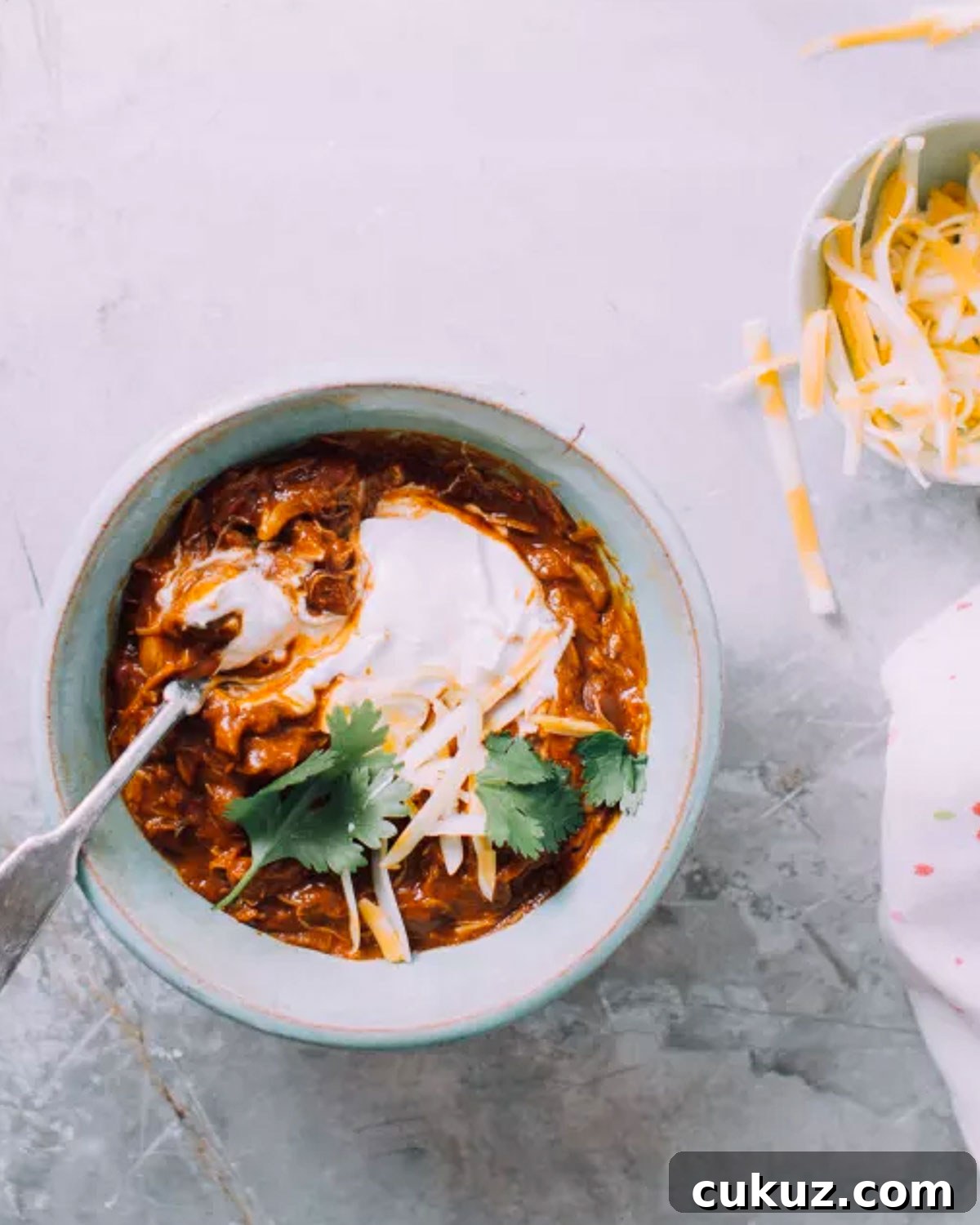 Instant Pot chicken chili in a bowl with sour cream and cilantro.