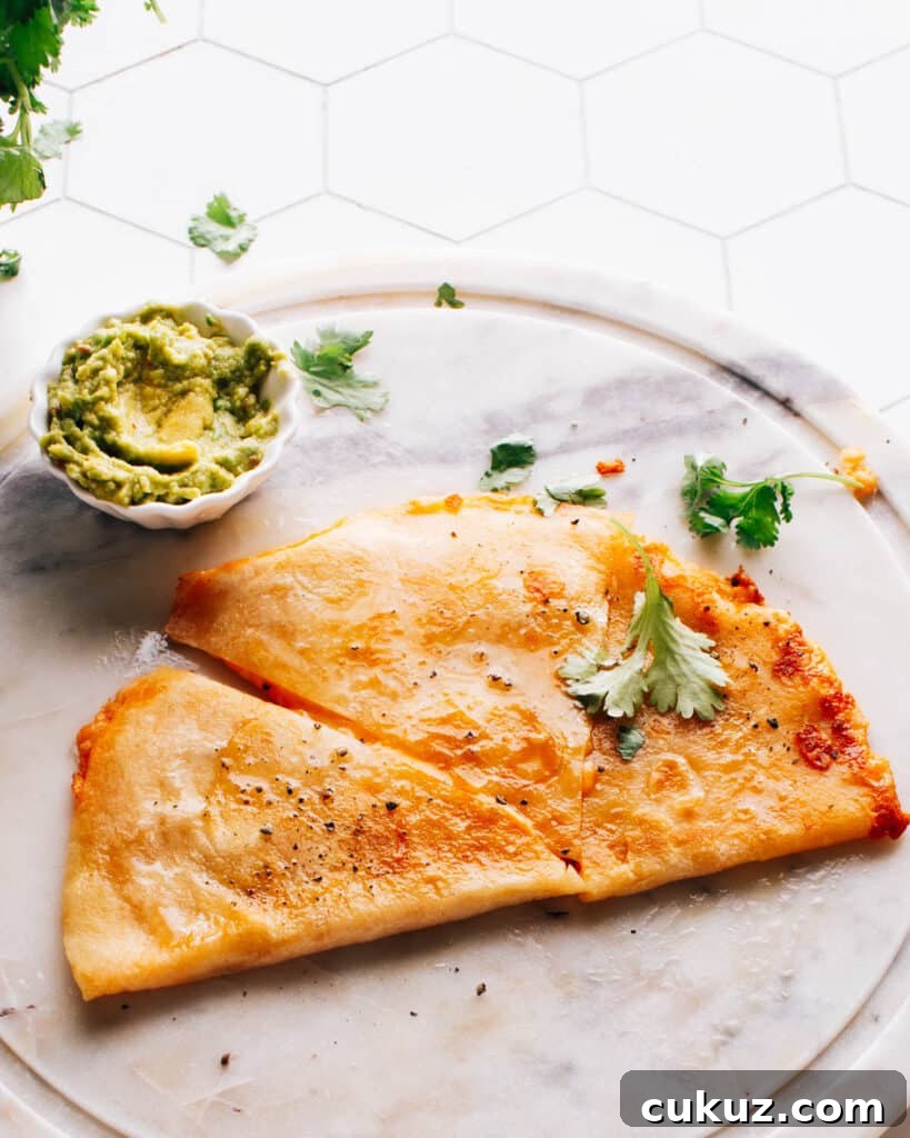 Cheese quesadilla on a plate with guacamole.