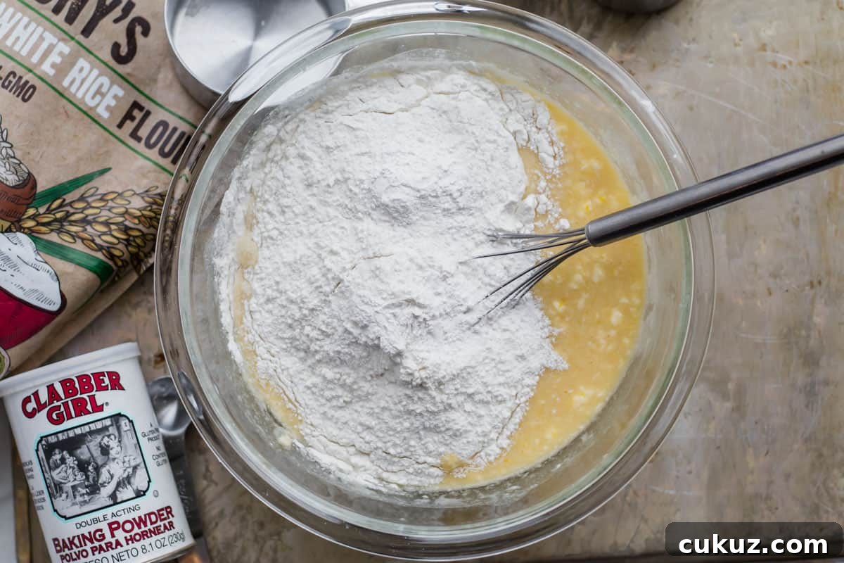 dry ingredients being added to a mixing bowl with mochi flour bag on the side.