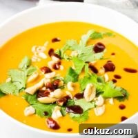 Creamy Vegan Sweet Potato Soup Recipe for Cozy Weeknights 8 A bowl of sweet potato soup topped with cilantro, peanuts and sriracha