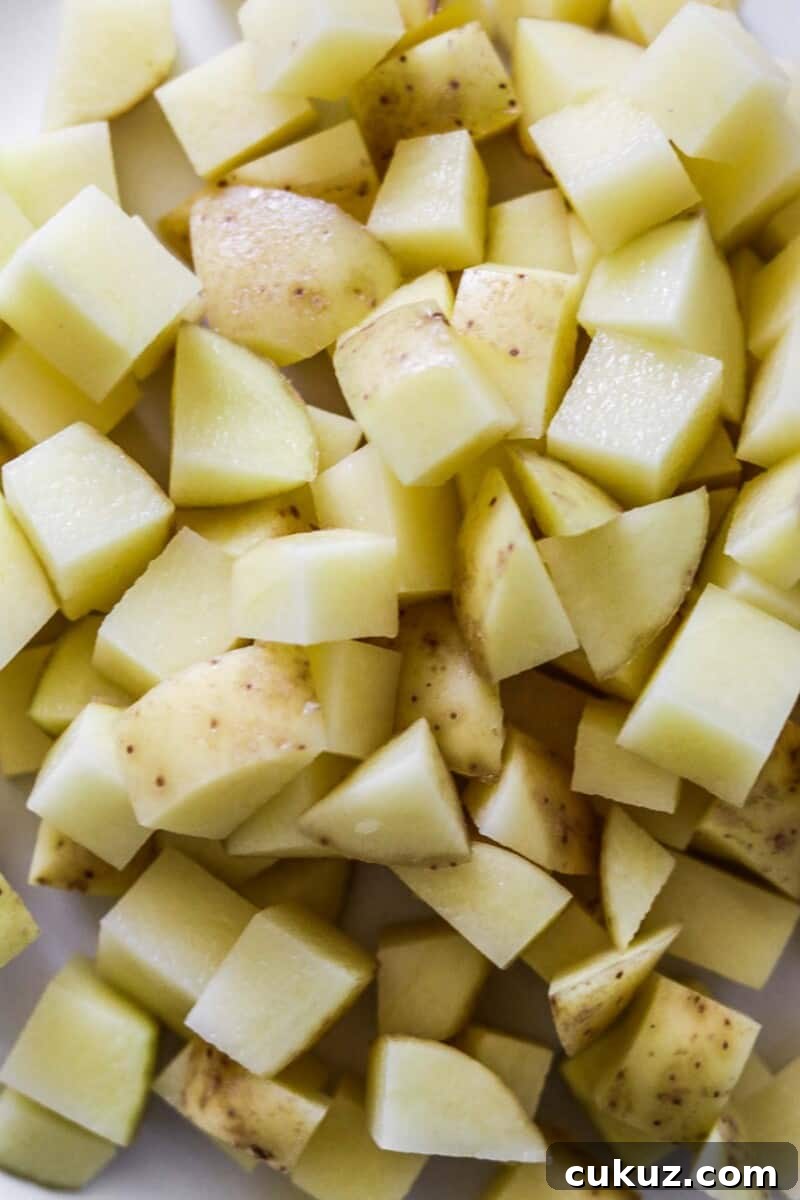 Cut up raw potatoes in a bowl.