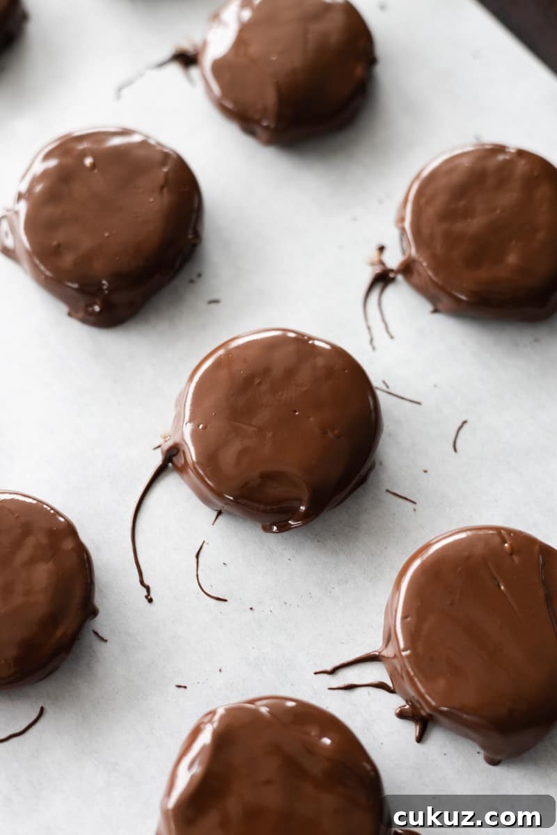 Chocolate coated cookies on a piece of parchment paper. 