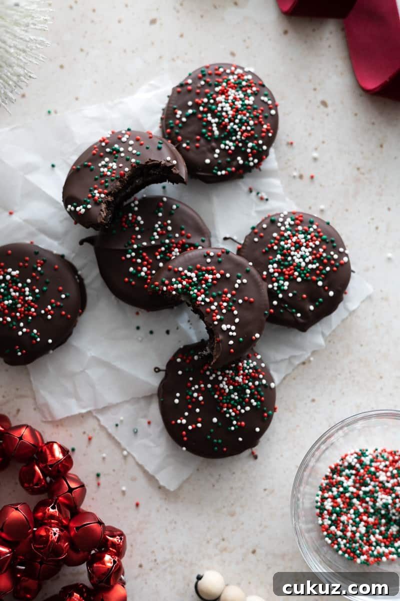 A stack of chocolate covered OREOs with red, green and white sprinkles. 