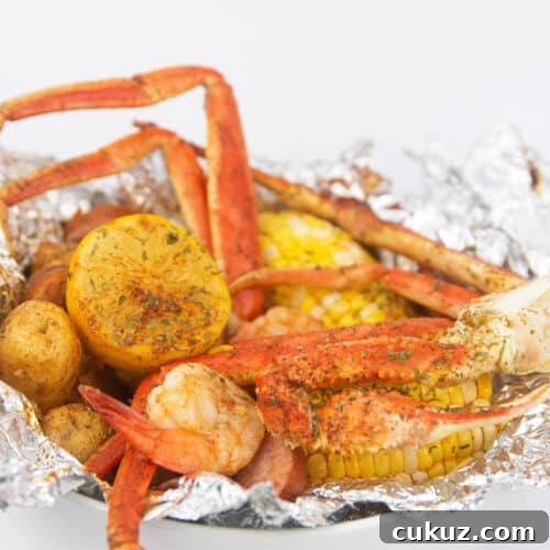 a white bowl of seafood, corn, potatoes, sausage and lemon in foil for seafood cajun boil packs