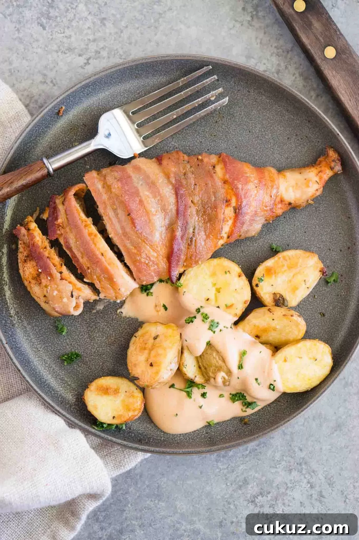 bacon wrapped chicken served with roasted potatoes