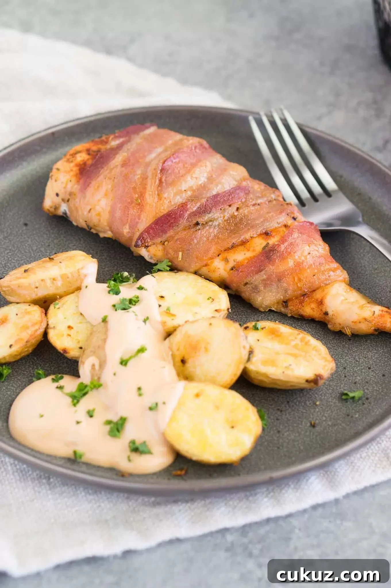 chicken breasts with bacon on a plate with potatoes