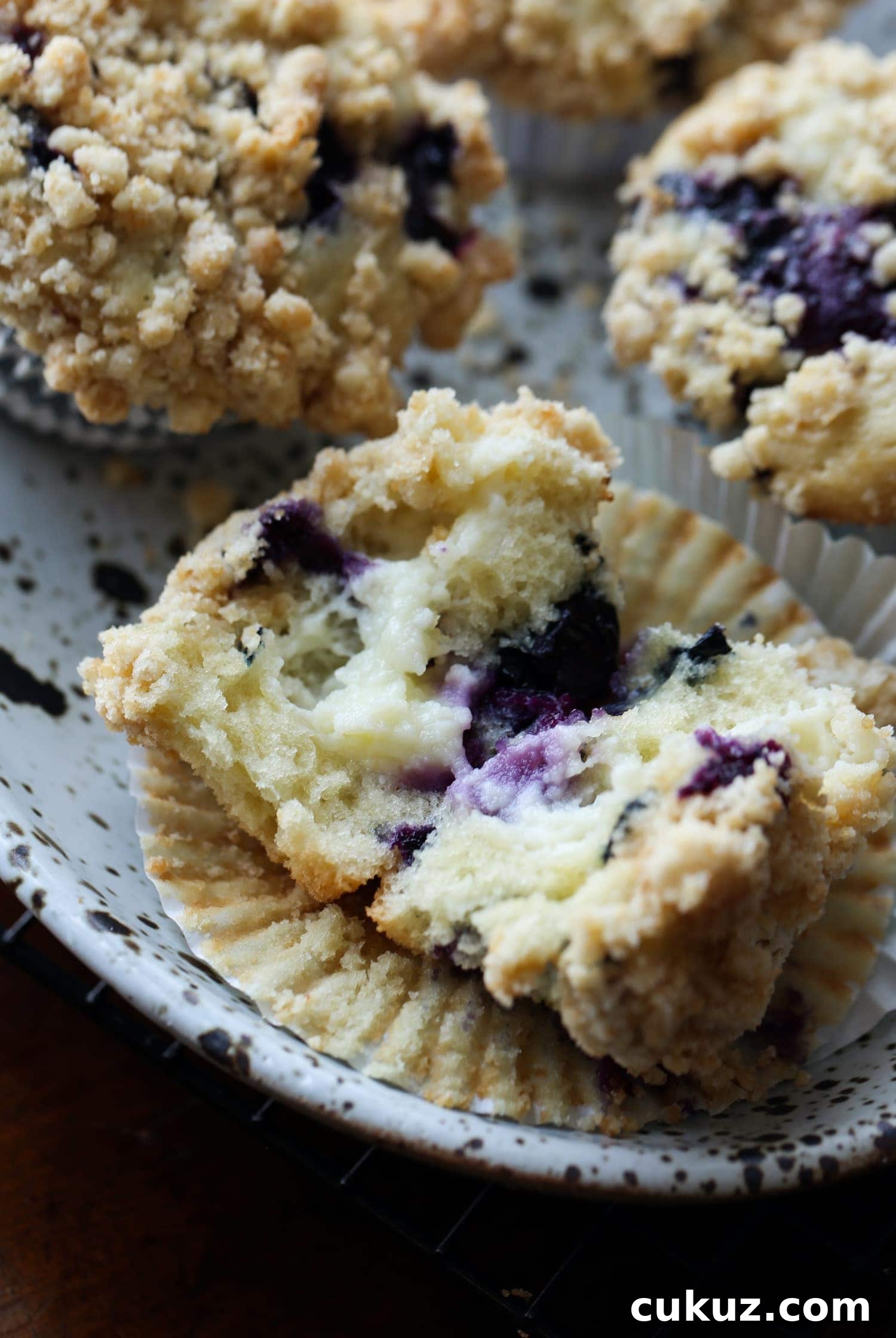 A blueberry muffin broken open to reveal the cream cheese filling.