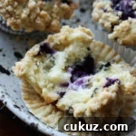 A blueberry muffin broken open to reveal the cream cheese filling.