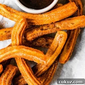 How to Make Crispy Homemade Churros with Chocolate Dipping Sauce 11 Churros recipe by easy weeknight recipes. The churros are served on a plate with a bowl of chocolate sauce.