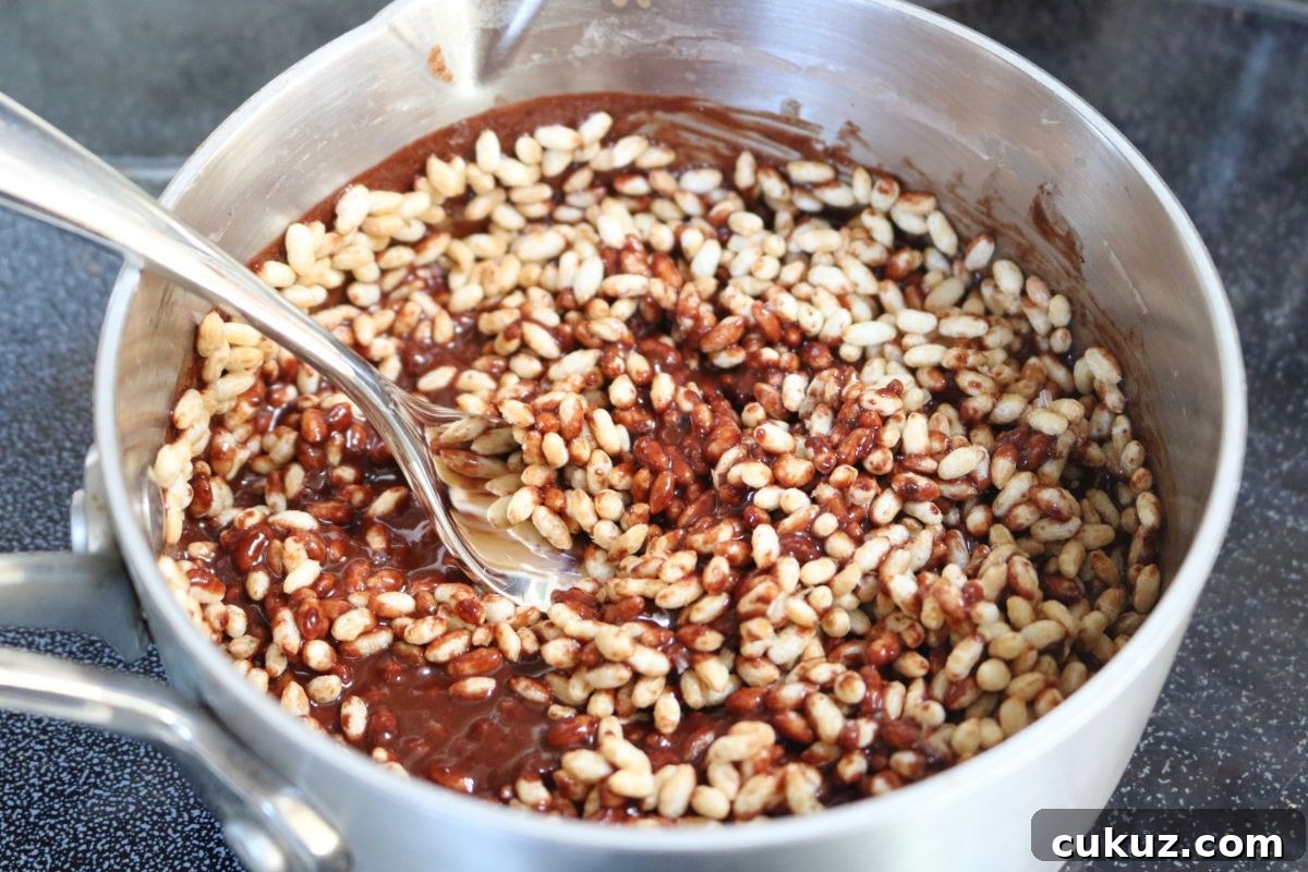 Peanut butter dark chocolate crunch bar mixture in a pot on the stove.