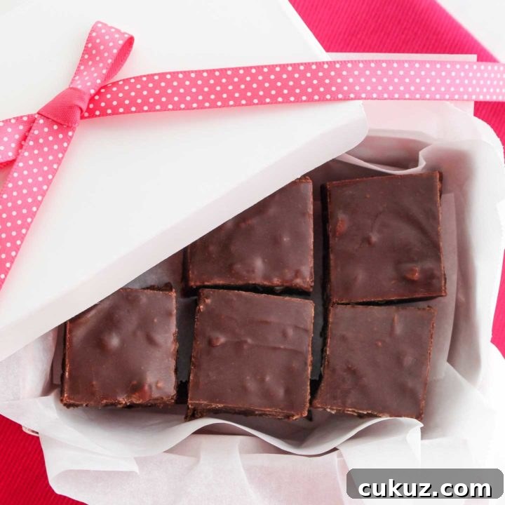 Overhead of squares of chocolate fudge layered in a white gift box