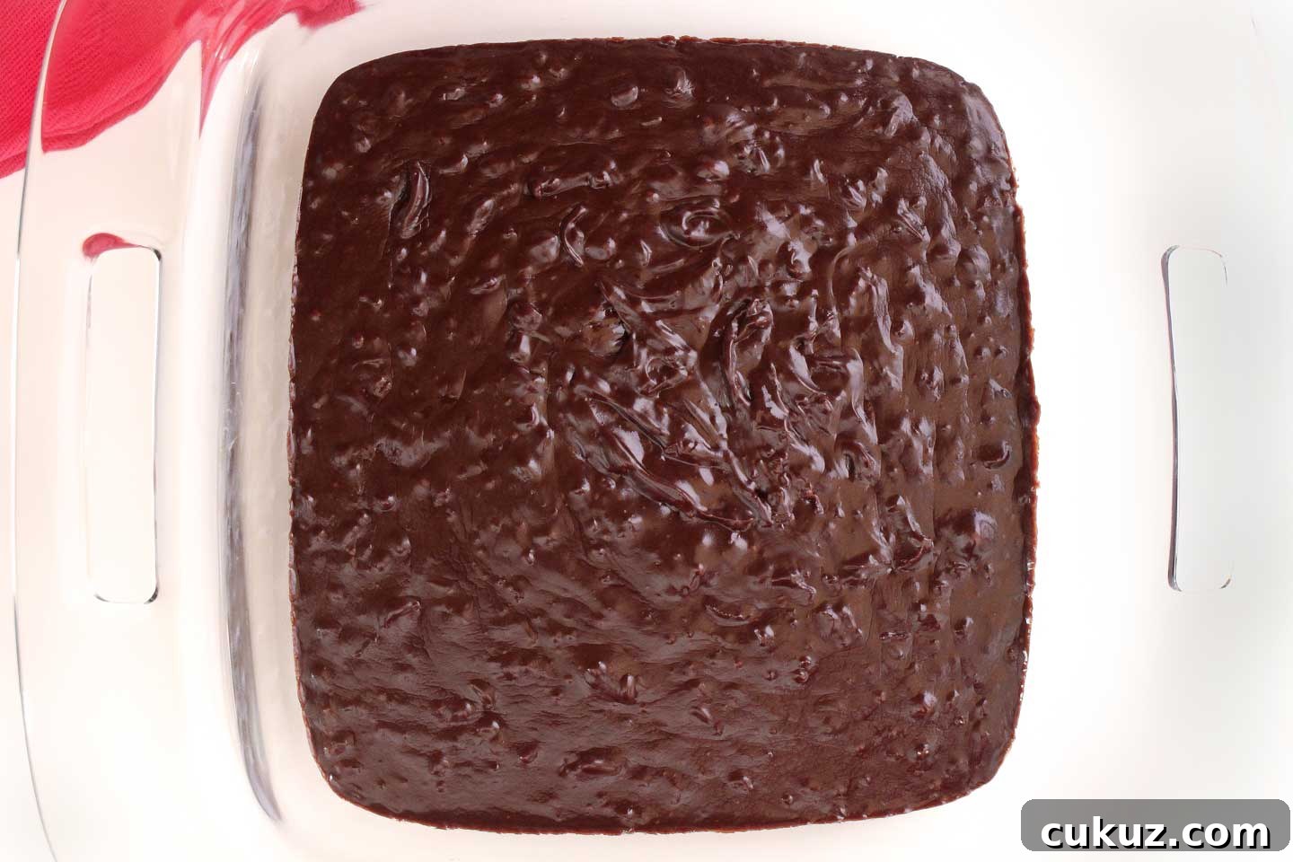 Warm fudge poured into a square pan to cool and set.