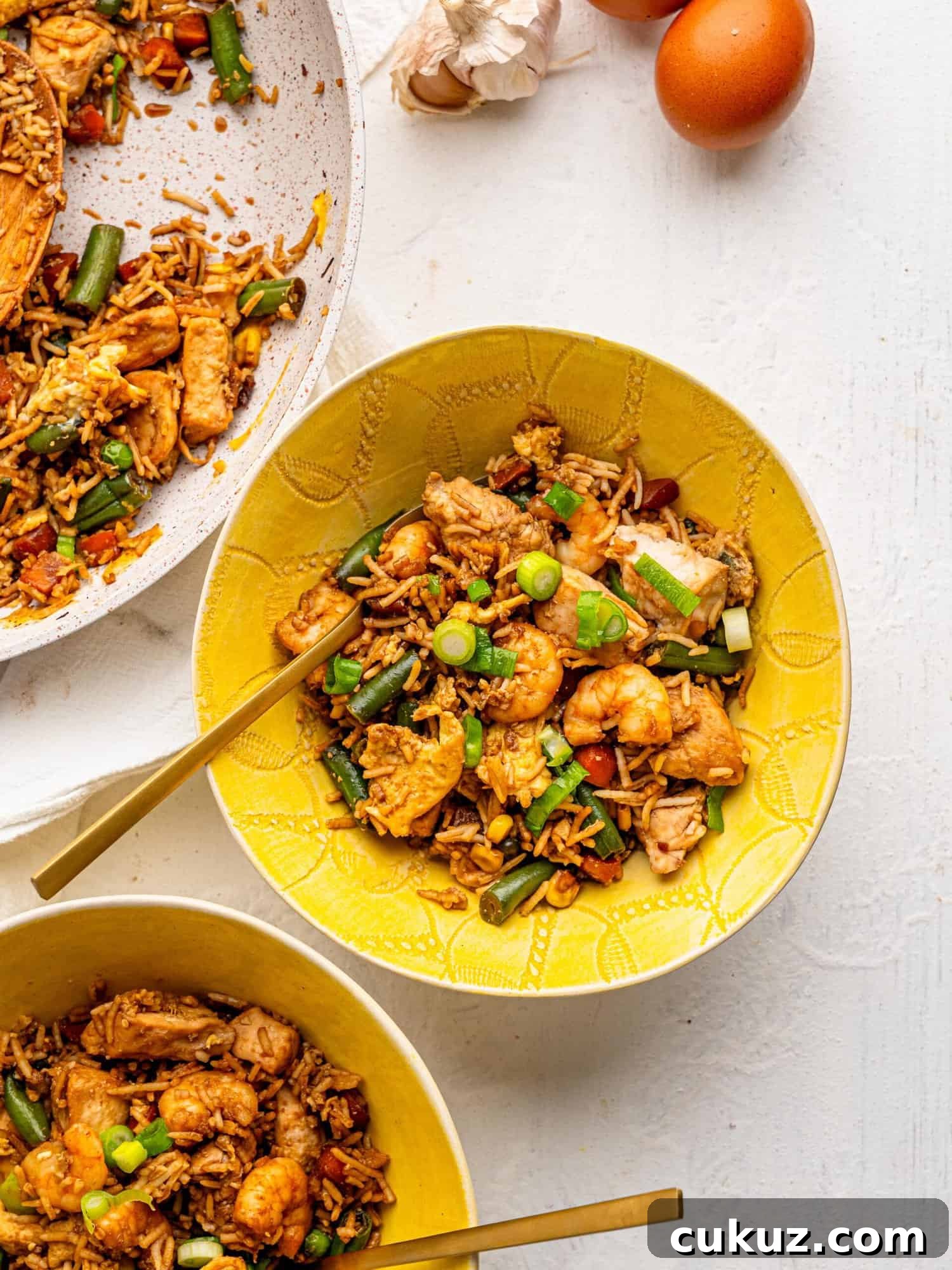 Chicken shrimp fried rice in a yellow bowl.