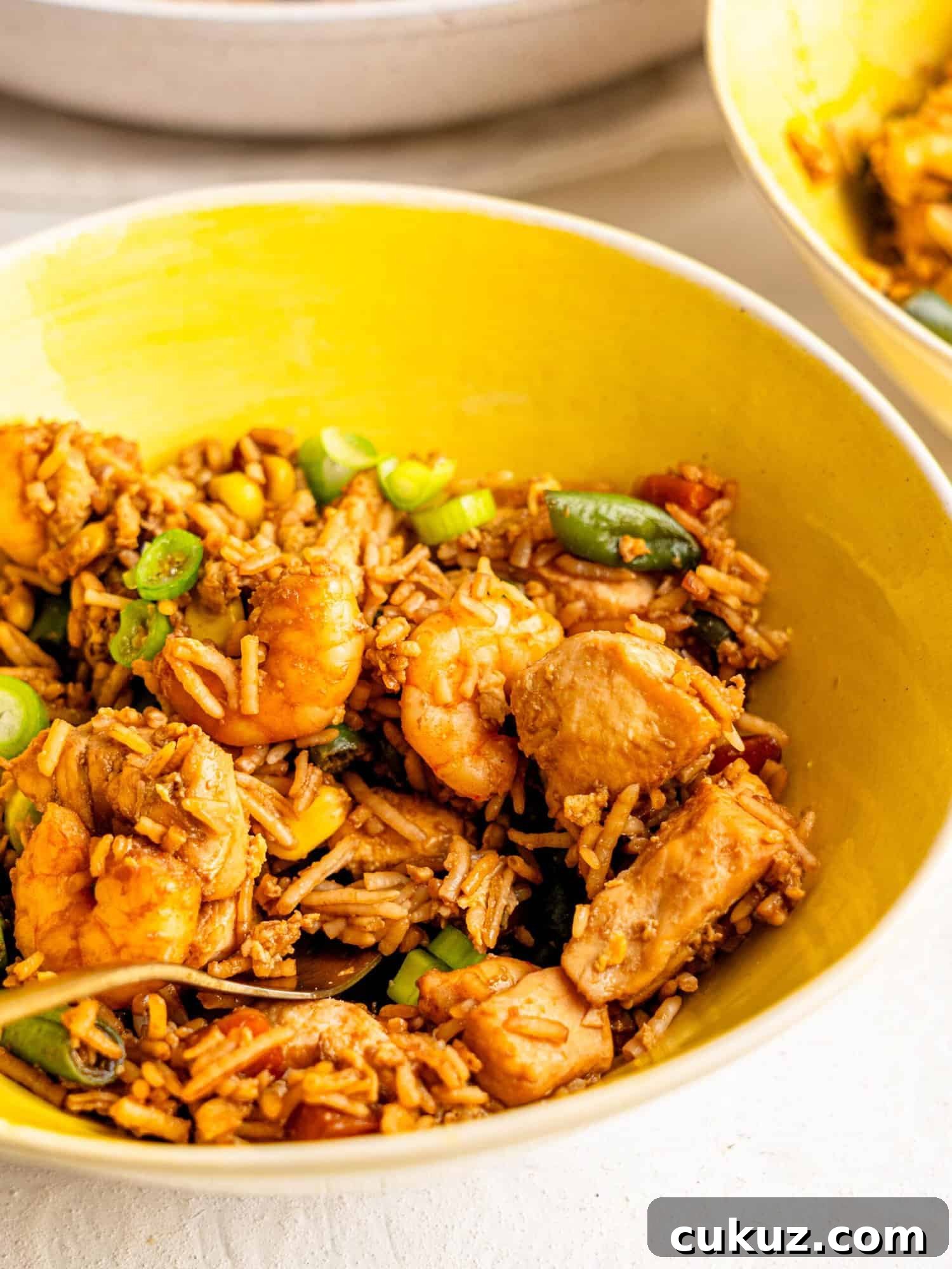 Chicken shrimp fried rice in a yellow bowl.