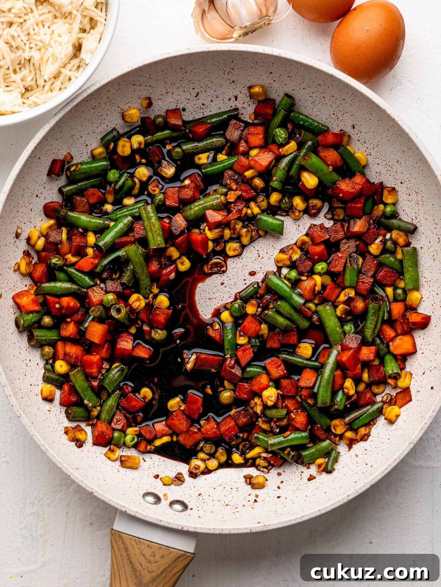 Mixed vegetables and soya sauce in a frying pan.