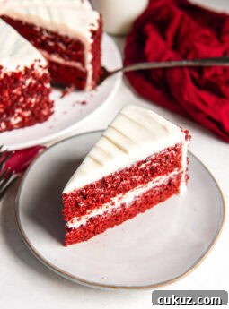 Slice of red velvet cake on a white plate.