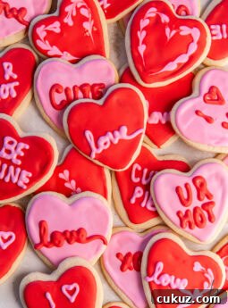 tabletop with heart shaped cookies decorated with red and pink icing.