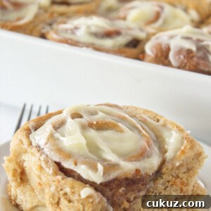 Carrot Cake Cinnamon Rolls with Cream Cheese Glaze 9 Serving a carrot cake cinnamon roll with cream cheese frosting.