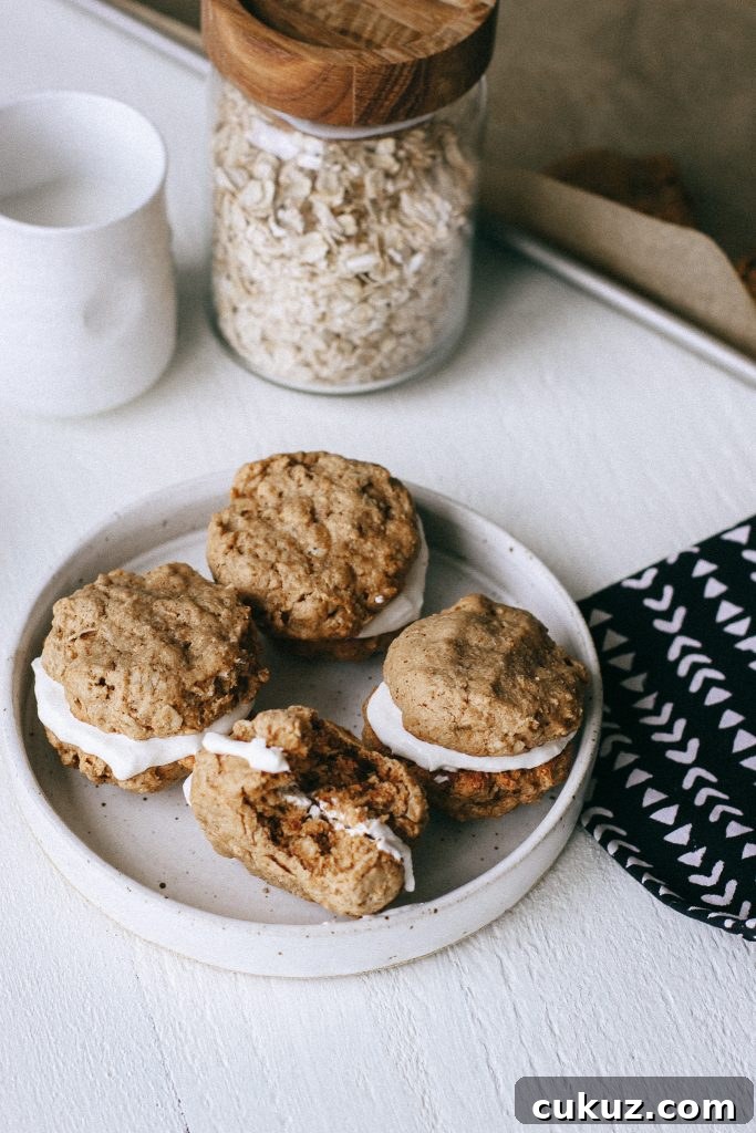 Low-Sugar Gluten-Free Oatmeal Cookie Sandwich with Cinnamon Yogurt Filling 5 Oatmeal cookie sandwiches with yogurt filling on a white plate