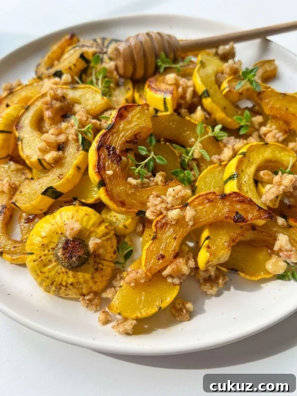 Viral Cabbage Boil Recipe: How to Make the Trendy Cabbage Pot 7 A plate of Roasted Delicata Squash and yellow pattypan squash, topped with chopped walnuts, fresh herbs, and a drizzle of honey. A honey dipper rests on the plate.