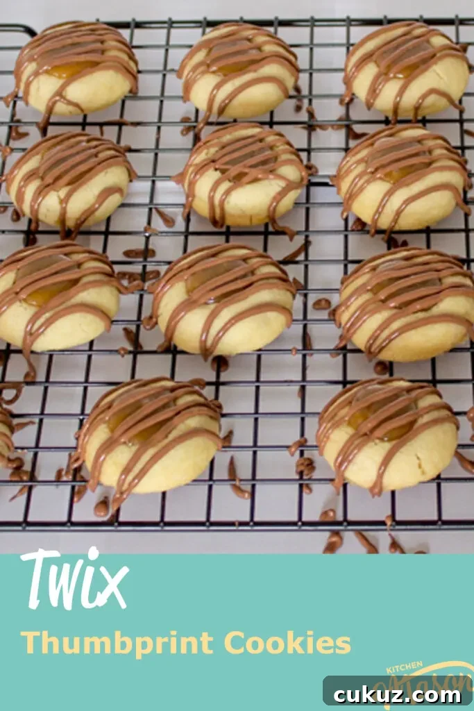 Twix thumbprint cookies on a wire rack set over paper