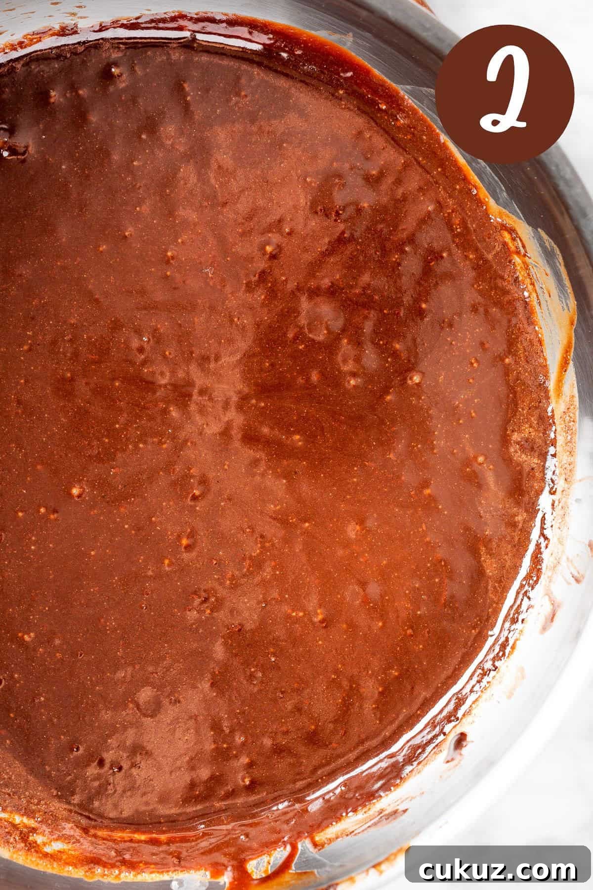 A process photo illustrating step 2: the chocolate sauce cooking in a saucepan.