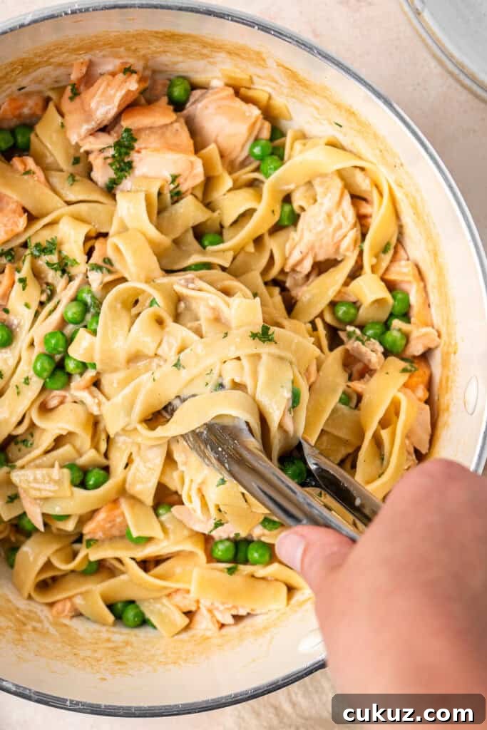 Creamy Dairy-Free Salmon Tagliatelle Recipe 9 Mixing the flaked salmon and peas into the creamy pasta.