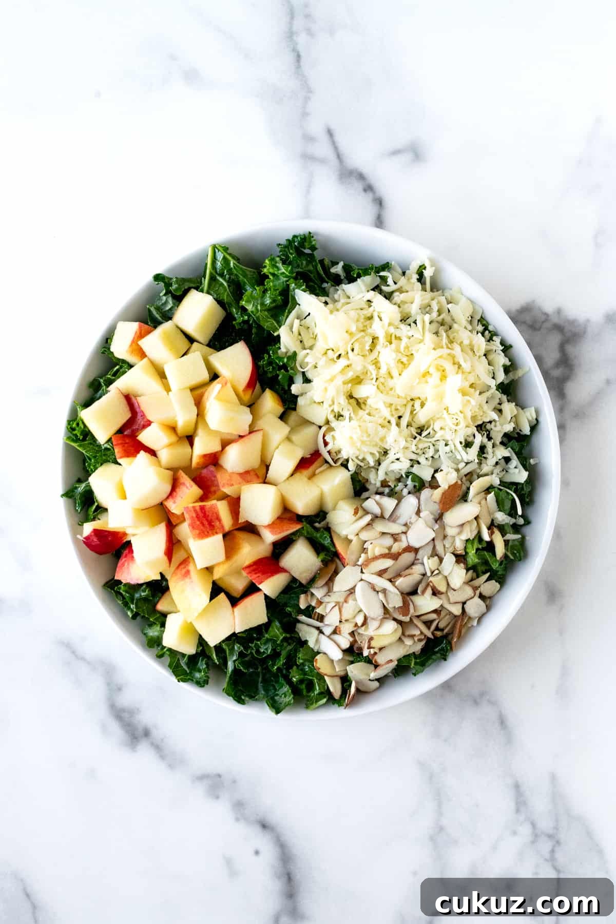 Kale Apple Cheddar Salad Ingredients in a White Bowl.
