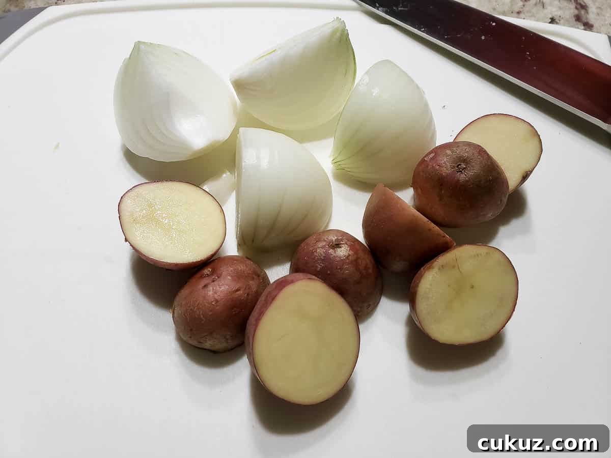 a quartered onion and red potatoes cut in half.