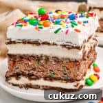 Slice of ice cream sandwich cake with sprinkles and M&Ms on top.