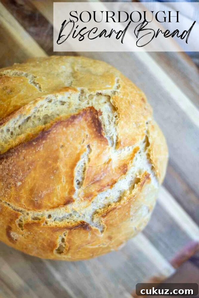 How to Make Delicious Bread with Sourdough Discard 2 overhead photo of a loaf of crusty sourdough discard bread on a wood cutting board