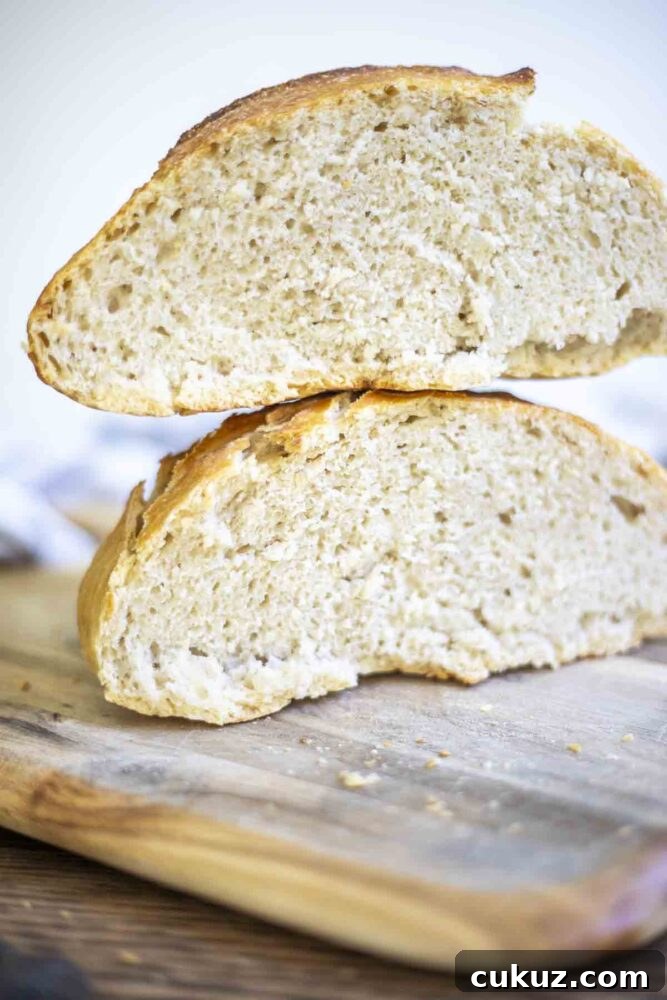 How to Make Delicious Bread with Sourdough Discard 3 two halves of sourdough discard bread stacked on top of each other on a wood cutting board
