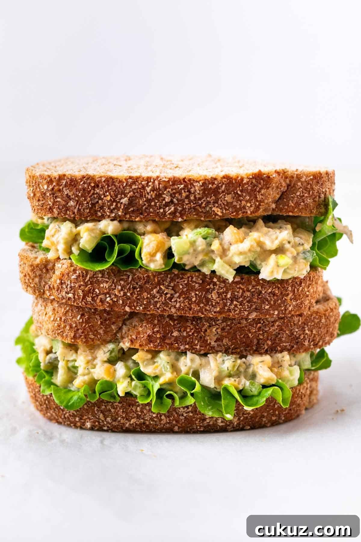 Plant-based chickpea salad sandwich with lettuce, halved and stacked for serving