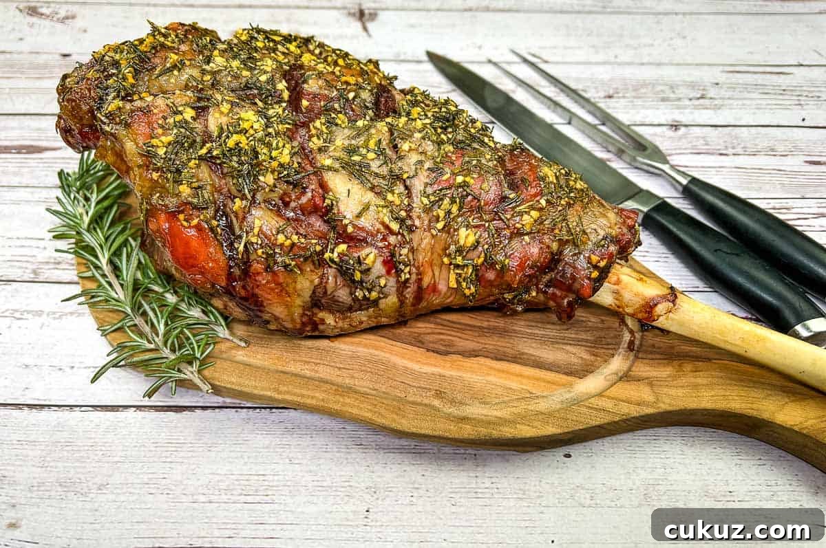 Whole cooked leg of lamb on a board with a knife.