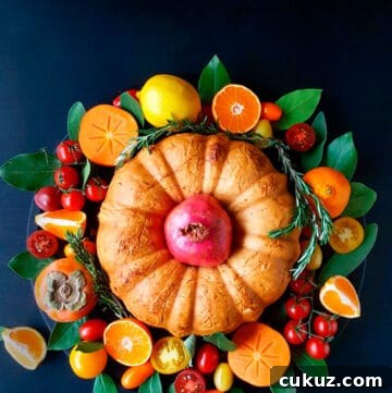 An overhead shot of fillo bundt in the middle of fruit and veggie wreath on a dark background