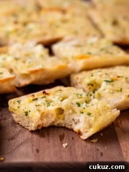 piece of ciabatta garlic bread with a bite taken out of it.