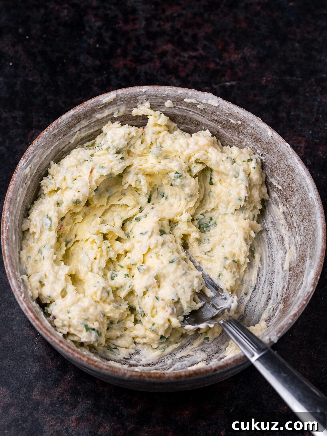 garlic parmesan butter mashed together in a bowl with a fork