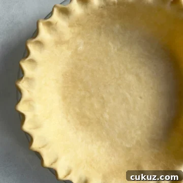 Pie crust in a pie pan with a fluted edge.