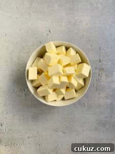 Butter cut into cubes in a white bowl.