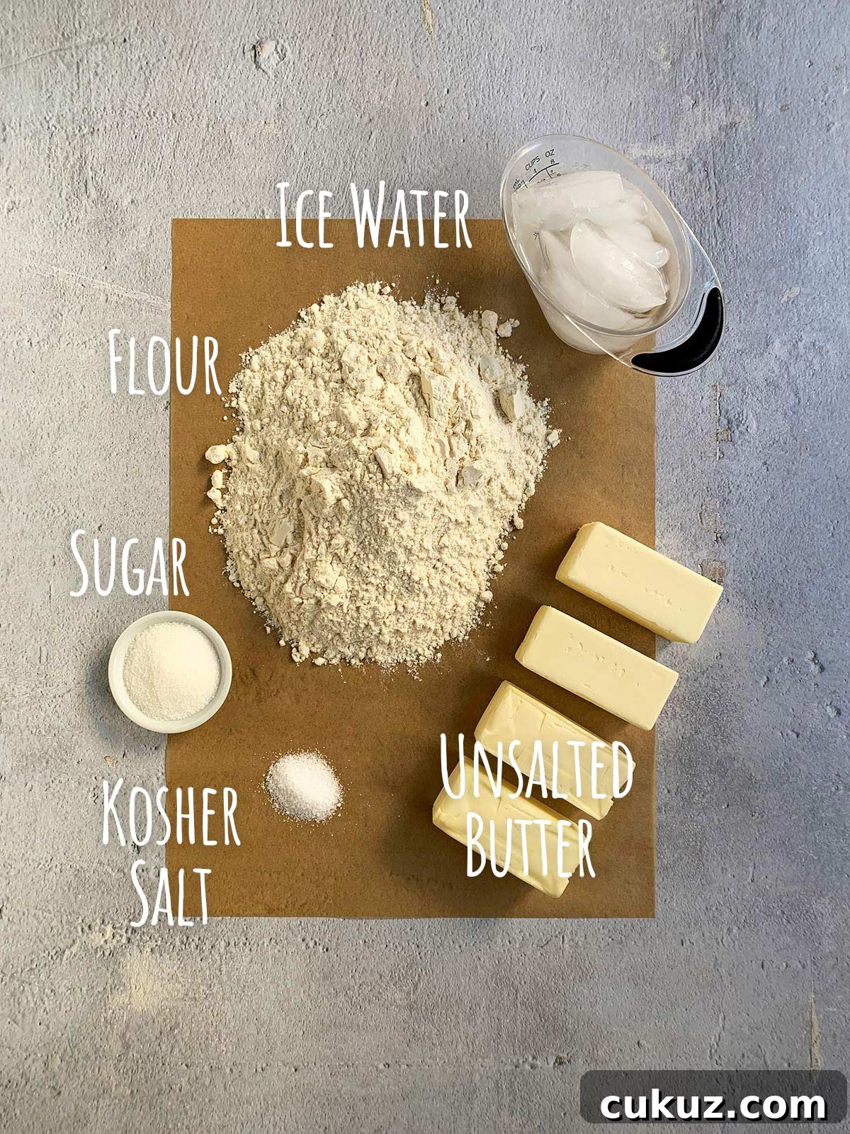 Ingredient shot for pie crust showing butter, sugar, flour, salt and ice water.