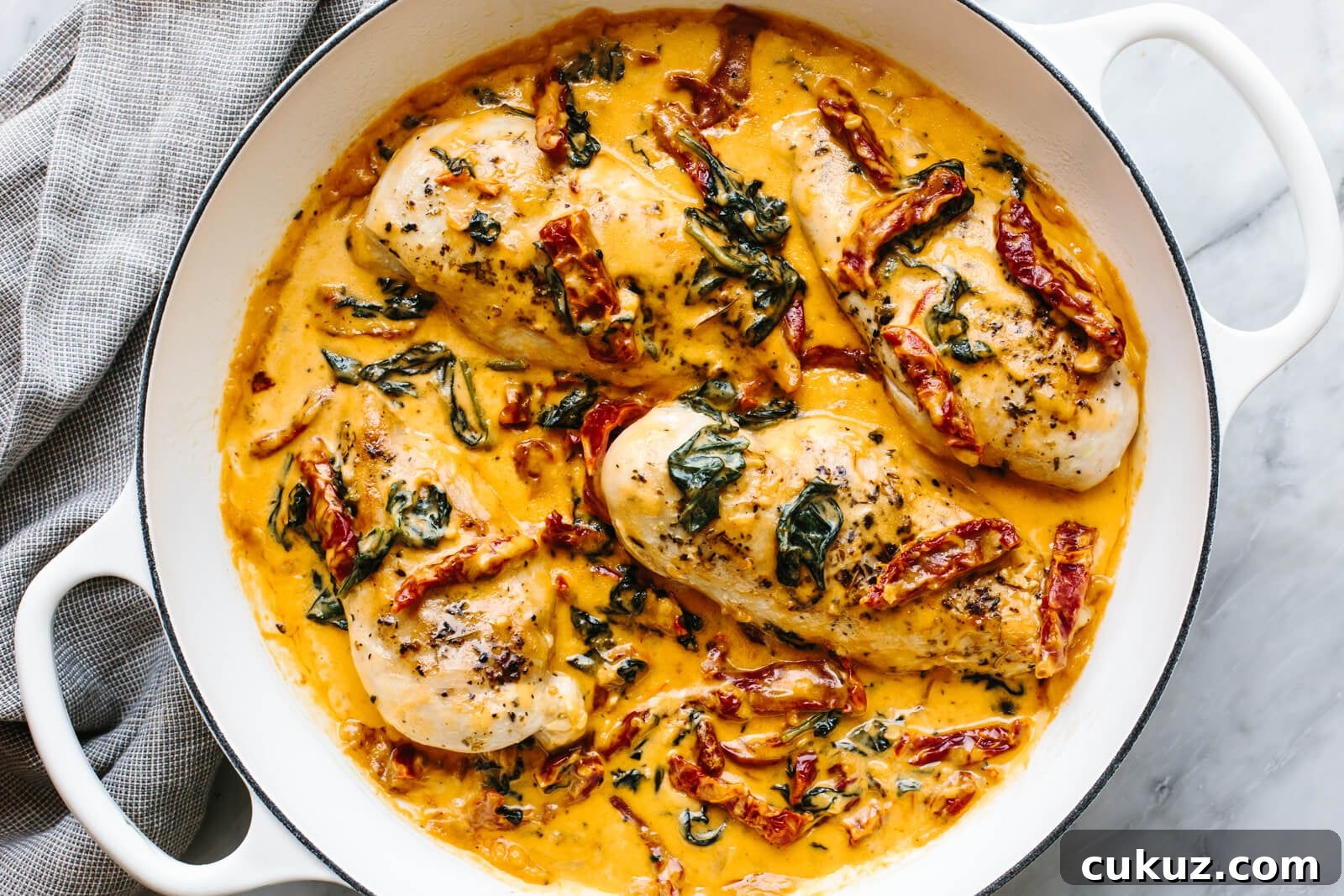 A white skillet of tuscan chicken
