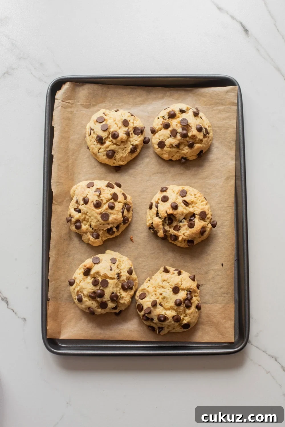 Thick chocolate chip cookies baked until the edges are set and centers remain soft on a baking sheet.