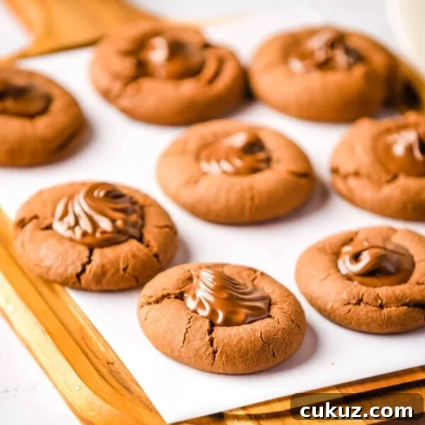 Close up of nutella cookies on a parchment lined wooden board.