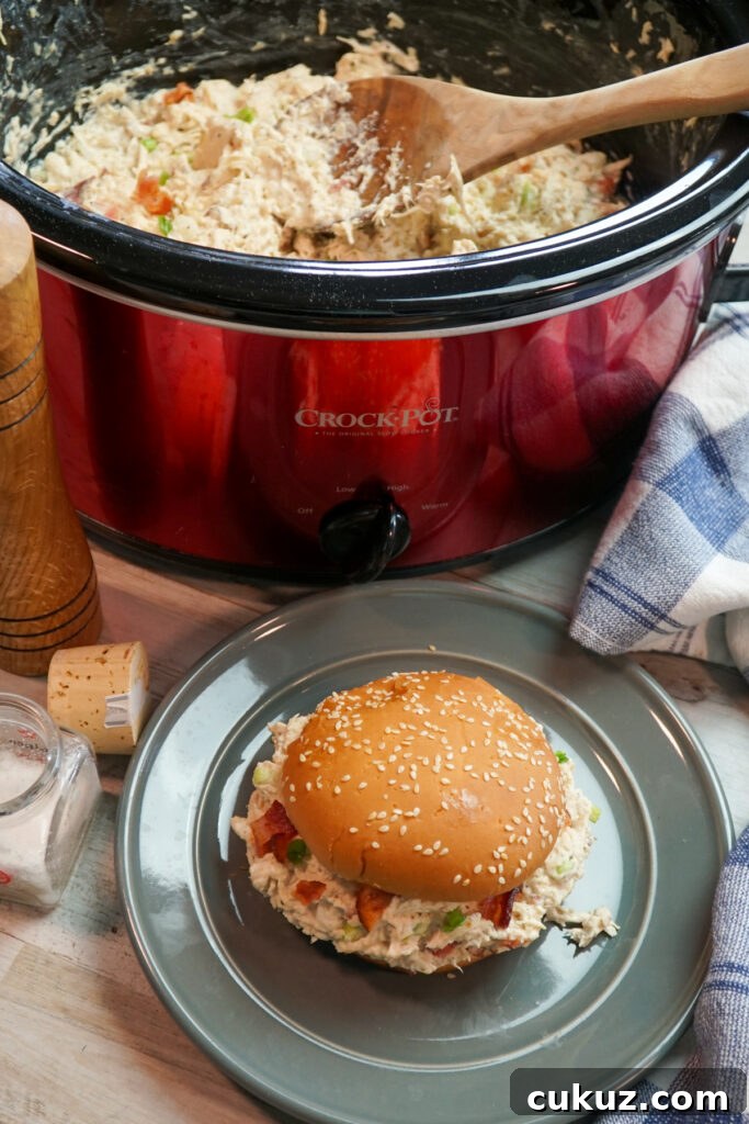 Slow cooker crack chicken - chicken in a crock pot and chicken sandwich on a plate. Over head shot.